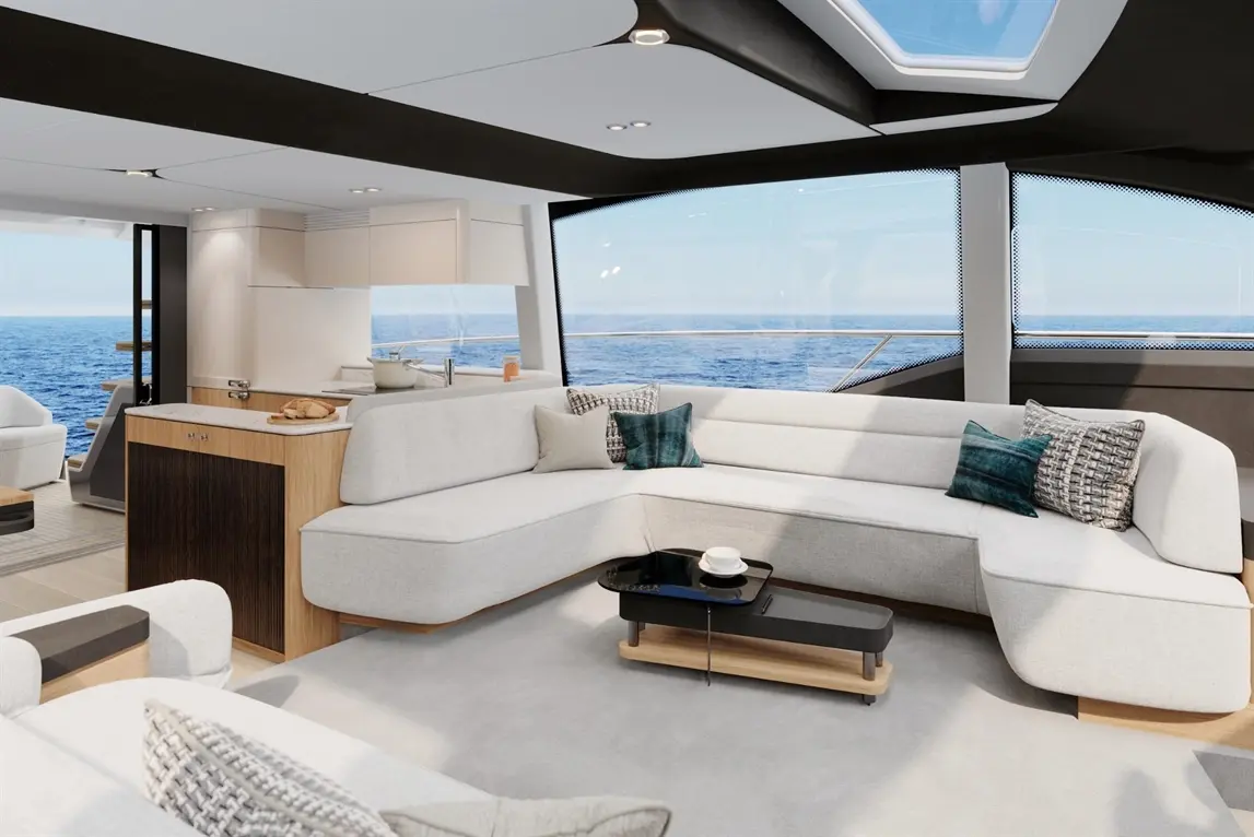 Modern yacht interior featuring a spacious lounge with a white sectional sofa, sleek coffee table, and ocean view.